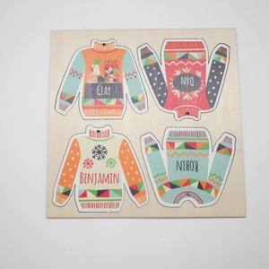Detail of custom wooden sweater ornaments with names and Nordic snowflake patterns