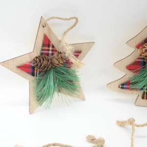 Detail of wooden Christmas ornaments with red plaid fabric, pine cones and needles