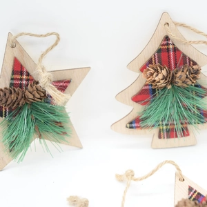Detail of Christmas wooden pendant with pine cones and red plaid fabric texture