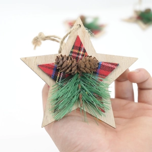 Close-up of wooden star ornament with plaid fabric, pine cones and green pine needles