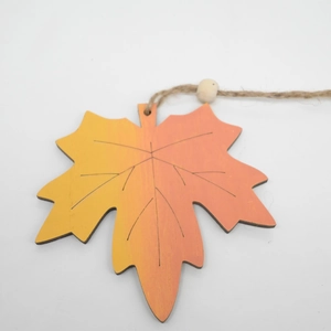 Detail of wooden maple leaf pendant with orange gradient finish and jute rope with wood bead