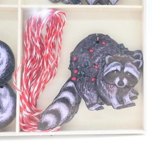 Detailed close-up of wooden raccoon Christmas ornaments in a natural storage box