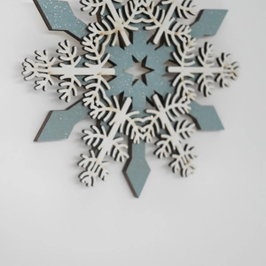 Christmas wooden snowflake ornament with layered star detail and grey-blue rustic finish
