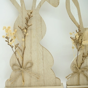 Close-up of wooden Easter bunny decor with natural wood grain and dried flower detail