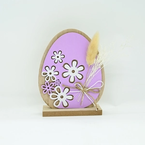 Close-up of Easter wooden egg ornament with purple finish and dried flower details