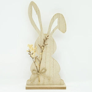 Close-up of wooden Easter bunny with twine bow and dried flowers on steady base