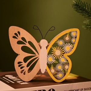 Vue détaillée de l'ornement papillon en bois ajouré avec motif de marguerite jaune et blanc