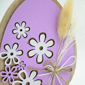 Detail of light purple wooden Easter egg ornament with dried flowers and jute bow