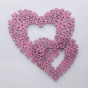 Detail of pink laser-cut floral double heart wooden hanging decoration for weddings