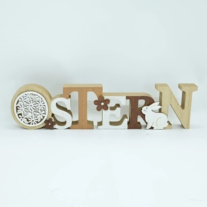 Detail of wooden OSTERN letters with cutout flower patterns and white bunny figurines
