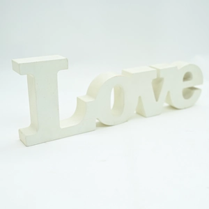 Close-up of matte white wooden LOVE letter sign for home decor and wedding setting