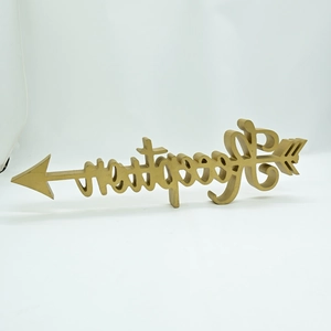 Detail of a matte gold arrow desktop ornament with artistic hollow letters on white base