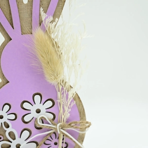 Close-up of wooden Easter bunny with lavender finish and dried flower bow detail