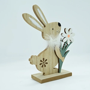 Detailed view of a wooden Easter bunny ornament with white feathers and daisy on a base