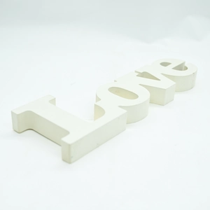 Macro 45-degree angle view of matte white wooden LOVE standing letter ornament