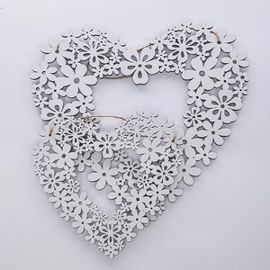 Close-up of laser-cut wooden heart floral wreaths with rustic twine for home decoration
