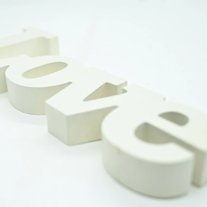 Macro shot of 3D white LOVE wooden letters showing smooth texture and matte finish