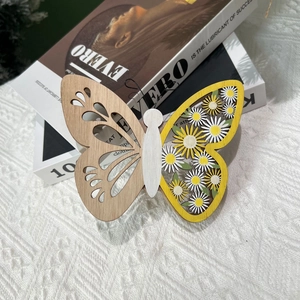 Décoration de Pâques en bois papillon évidé avec motif marguerite sur livres nordiques