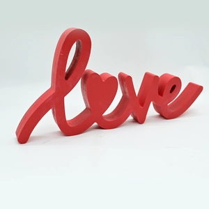Macro side view of red wooden Love tabletop sign with heart detail for home decor