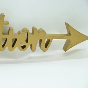 Macro detail of golden 3D letter ornament with a glossy finish and arrow indicator