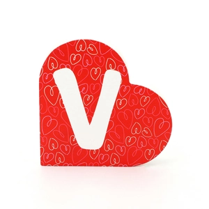 Vue rapprochée d'une décoration en bois en forme de cœur rouge avec une lettre V blanche