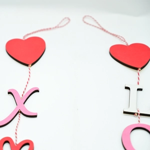 Detail of wooden Valentine heart and letter charms with natural laser-cut texture