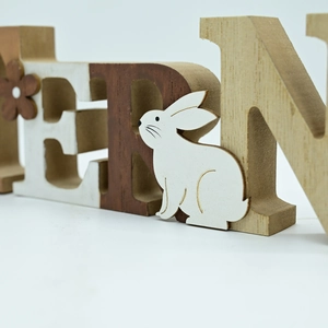 Rustic Easter wooden block letters with white bunny and floral accents on white background