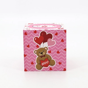 Pink heart-themed square gift box featuring a brown bear and red lip print accents