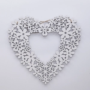 Detail of white laser-cut wooden heart wreath featuring delicate floral patterns