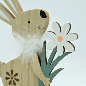 Detailed close-up of wooden Easter bunny craft with white feather neck and floral accent