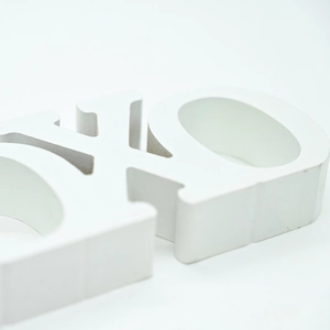 Macro detail of a 3D white wooden letter decor with smooth matte finish and thick edges