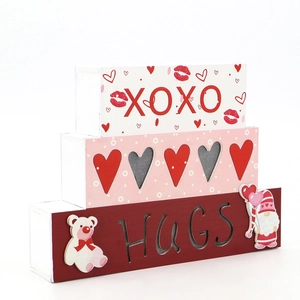 Détail de blocs en bois empilés XOXO et HUGS avec motifs de nains et de cœurs
