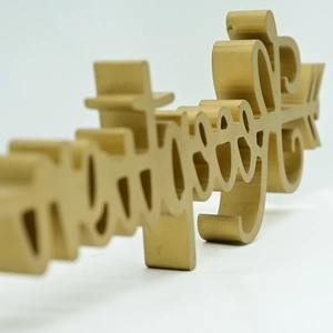 Close-up of golden artistic letter decor with metallic finish and romantic arrow design