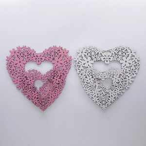 Close-up of laser-cut wooden heart wreath decorations in pink and white with hanging twine