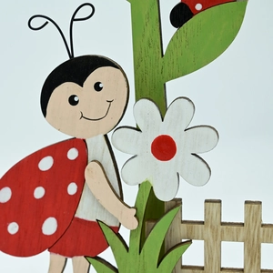 Décoration de Pâques en bois avec coccinelle, fleur blanche et feuilles vertes