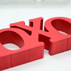 Detailed close-up of 3D red XOXO wooden letters with matte finish for home decor