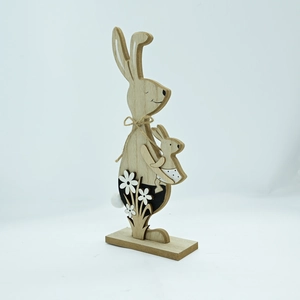 Detailed view of wooden Easter rabbits with twine bow and floral accents on base