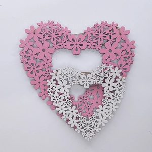 Detail of pink and white wooden heart wreaths with floral cutouts and hanging strings