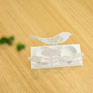 Detailansicht weißer Metall-Osterkerzenhalter mit Blumenmuster und Vogel-Silhouette