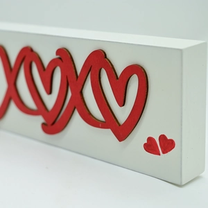 Close-up of XOXO wooden tabletop decor showing thick white base and red heart details