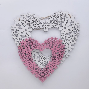 Macro detail of the nested pink and white heart-shaped wooden wreath with floral cutouts