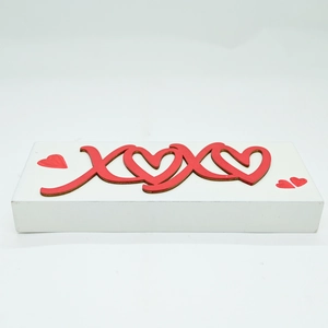 Close-up of white wooden XOXO block with red hearts for Valentine's home decoration