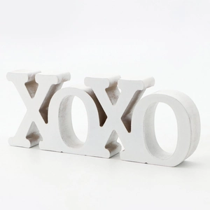 Detail of white XOXO wooden decor showing the vintage distressed finish and texture