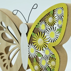 Détail d'un papillon en bois découpé au laser avec motifs de marguerites jaunes déco