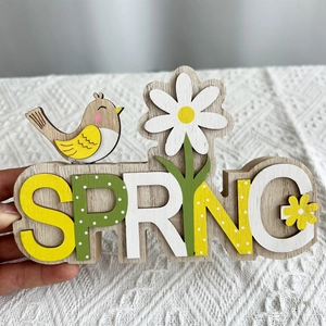Detail von SPRING Holzdeko mit Vogel und Gänseblümchen auf weißer Spitzendecke