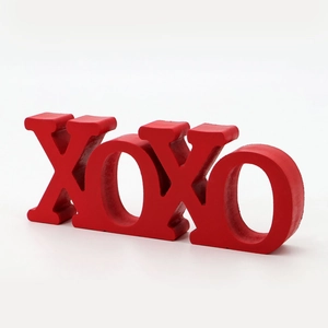 Close-up of bright red wooden XOXO letter blocks with subtle grain texture for decor