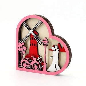 Detail of 3D layered wood ferris wheel decoration with heart frame and couple silhouette
