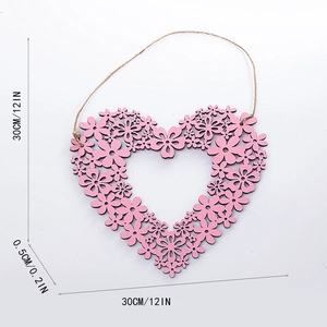 Detail view of pink heart-shaped wooden wall decor with laser-cut floral patterns and size info