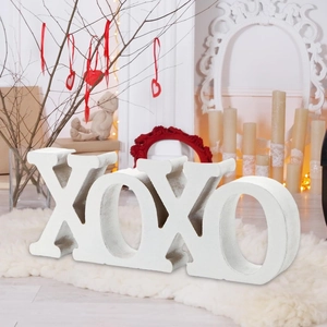 White wooden XOXO letter blocks home decor on cozy plush carpet for Valentines Day