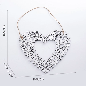 Detailed view of heart-shaped wooden wall hanging decoration with floral hollow pattern
